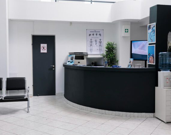 nobody waiting room with front desk reception wall screen tv with promotional offer private practice hopital waiting area patients with doctor appointments modern healthcare clinic